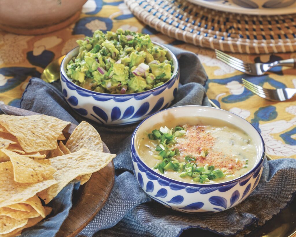 Bowls of guacamole and queso dip with tortilla chips