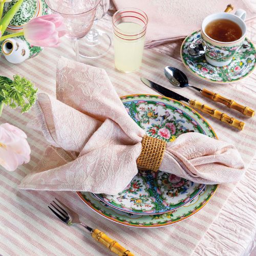 Pink table linens from Busatti accent a colorful spring place setting.
