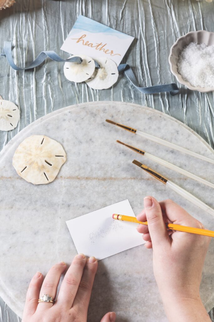 Hand erasing outline on paper