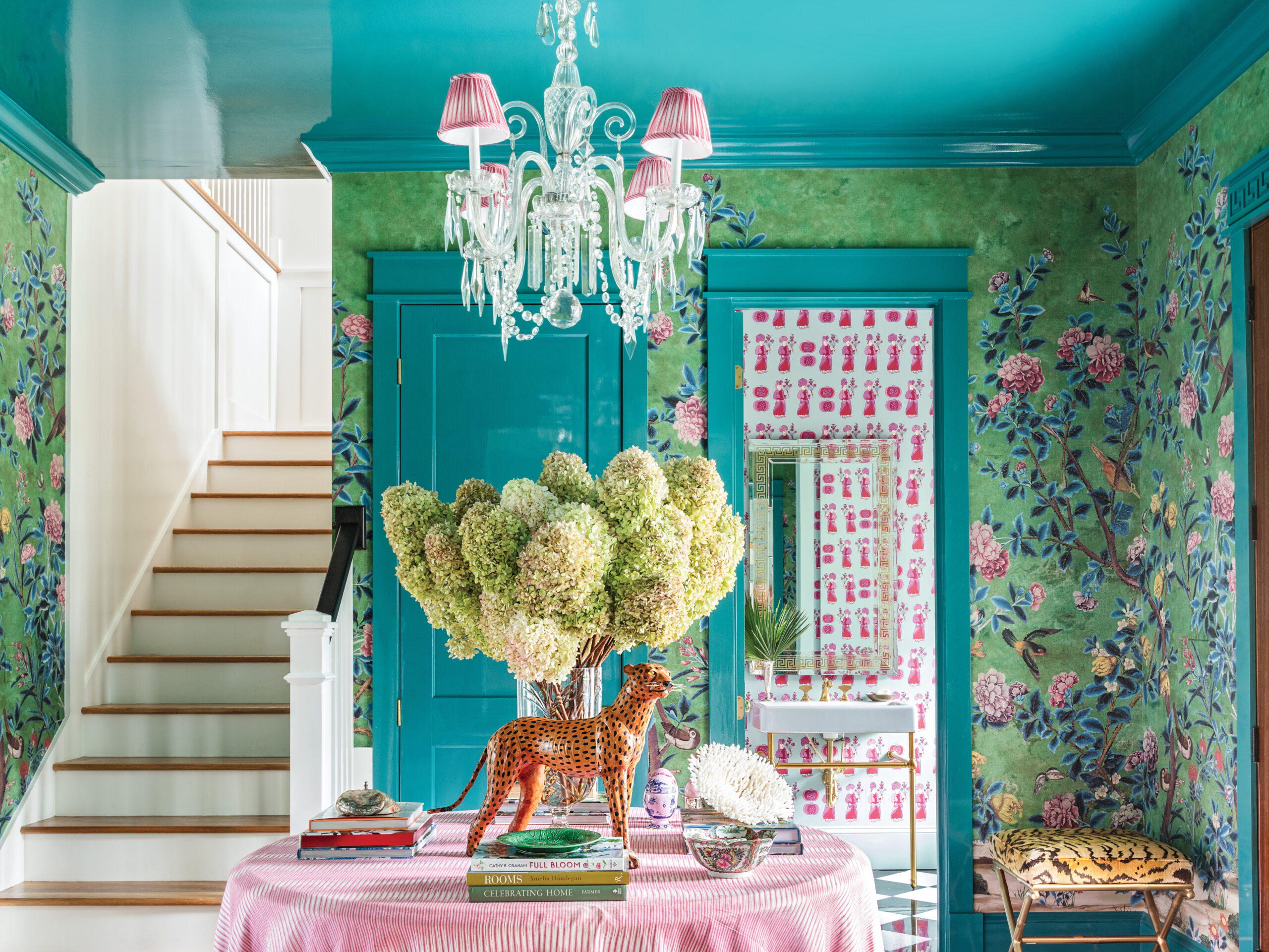 Table with florals and decorations in a room with blue patterned wallpaper