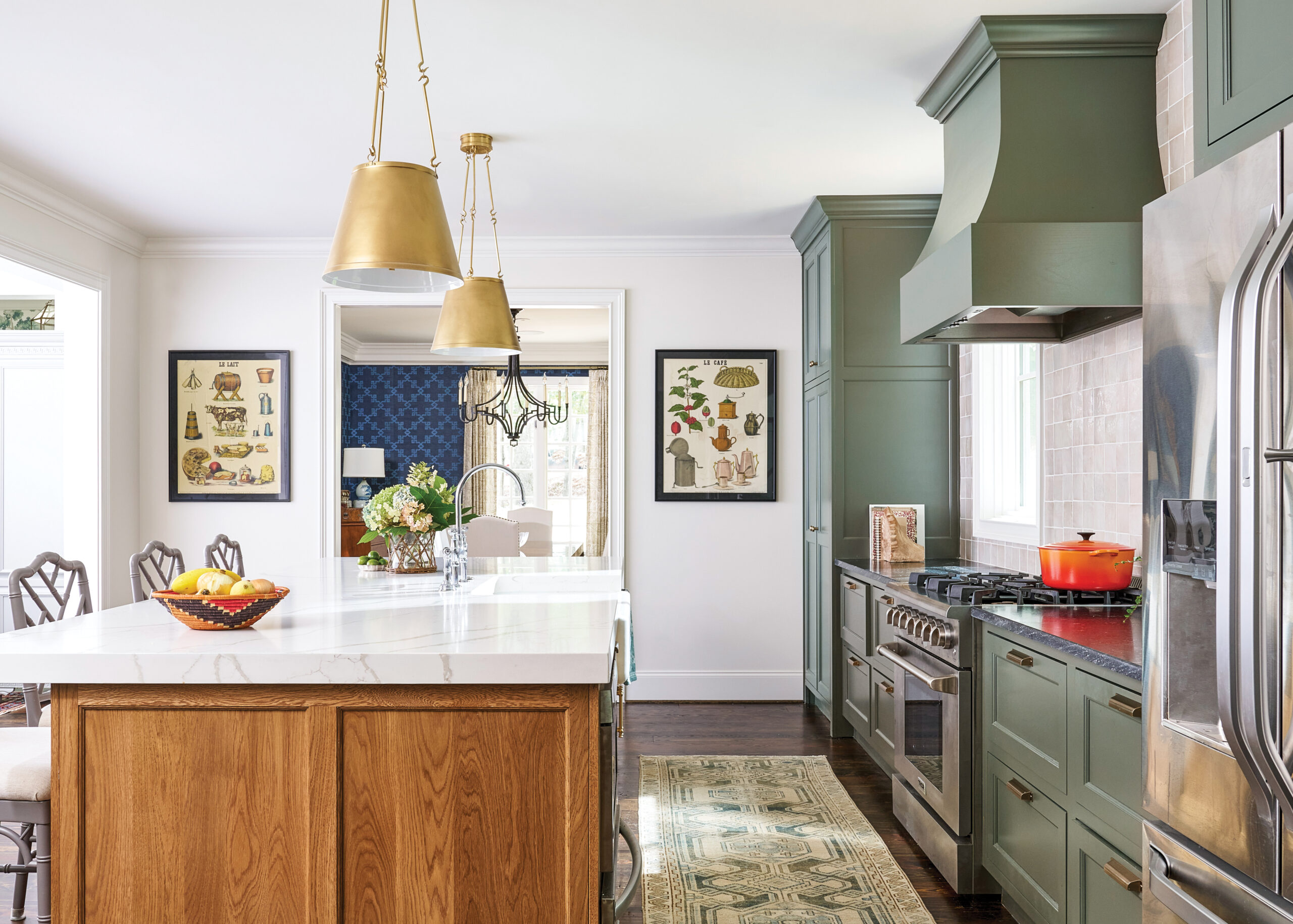 Kitchen with marble and wood island and green cabinets