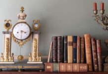 Time Will Tell: Mantel Clocks in Southern Homes Antique clock next to stacked books and a candelabra