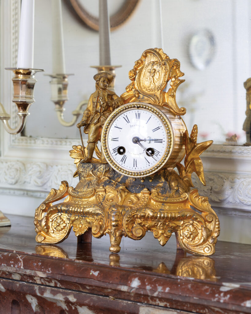 Ornate golden clock on mantel 