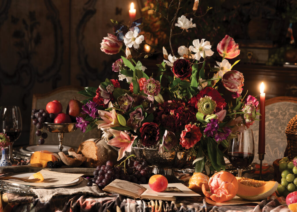 Large floral arrangement with fruit filled tablescape