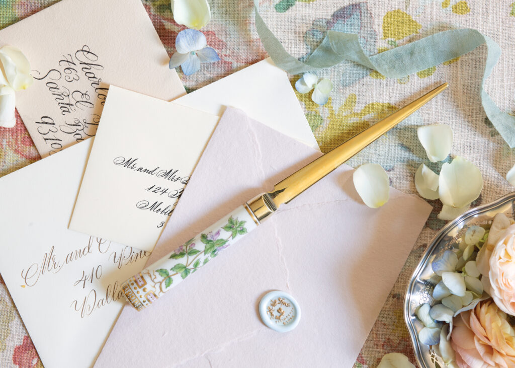 Dainty envelopes with floral petals and a golden letter opener 