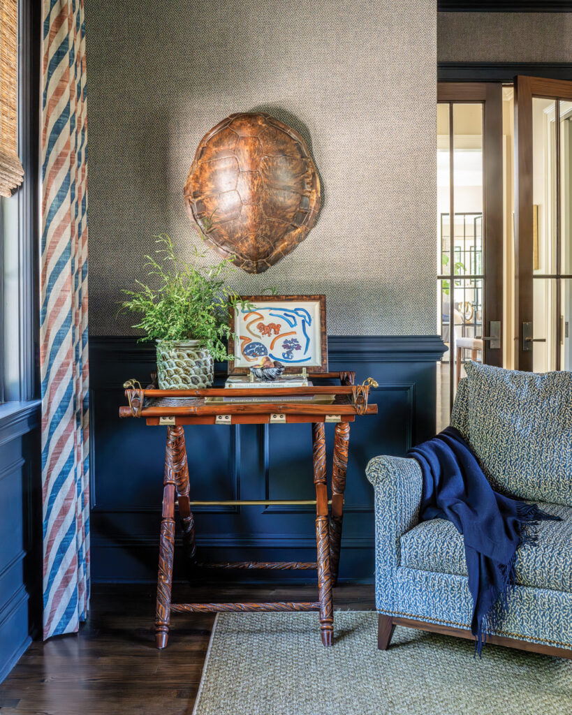 Comfy chair in nook next to window with turtle shell decor on wall