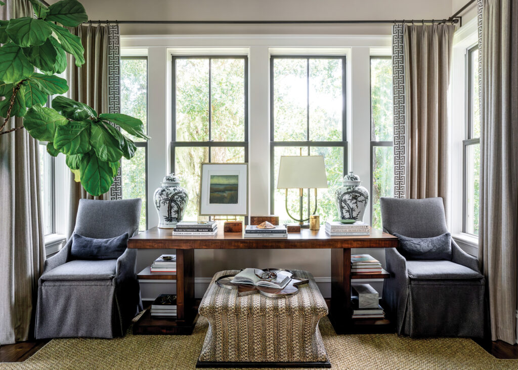 Nook with 2 blue chairs, a wooden table, and an ottoman