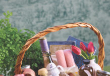 Celebrate Spring with an Adult Easter Basket An Easter basket filled with a bottle of wine, candlesticks, tulips, a book, and easter eggs.