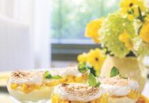 Mini Mango Cheesecake Trifles Mini mango cheesecake trifles in coupe glasses, served on a green tray.