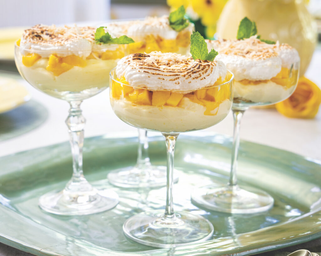 Four coupe glasses filled with a fruity dessert.