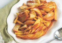 Cinnamon Apples Cinnamon Apples on a white platter, with a white anemone flower behind it