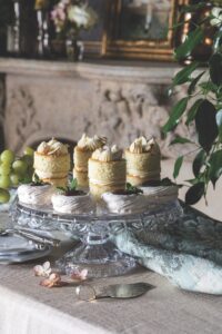 A crystal cakestand holding mini almond cakes and mini pavlovas. 