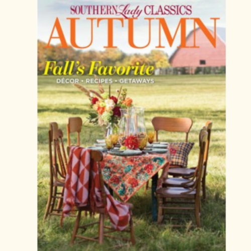 Cover for Southern Lady Classics Autumn issue: outdoor fall dining setup on a sunlit field with a colorful tablecloth, flowers, and wooden chairs