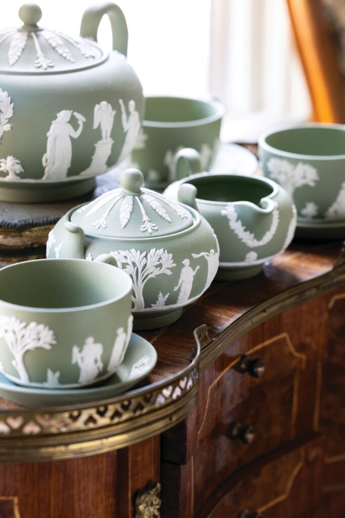 A celadon-green Wedgwood jasperware tea-and-coffee service banded in white bas-relief, set out on a polished wooden chest